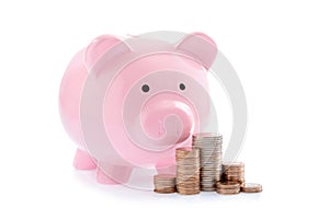 Pink piggy bank and Stacks of money coins