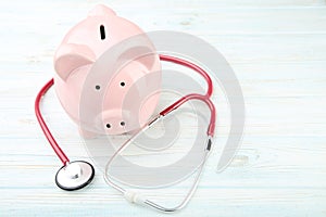 Pink piggy bank with stethoscope