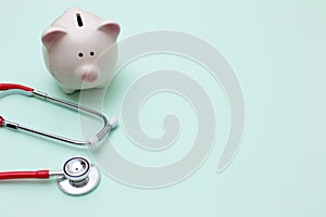 Pink piggy bank with stethoscope