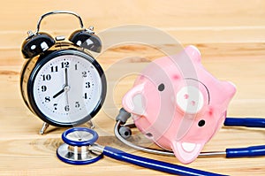 Pink piggy bank with stethoscope.