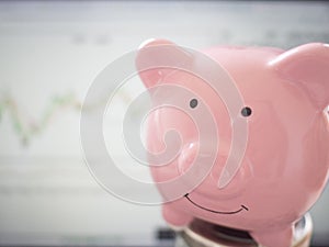 Pink Piggy bank  with stock graph background, Saving money for future plan and retirement fund concept
