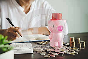 Pink piggy bank on table with coins