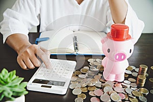 Pink piggy bank on table with coins