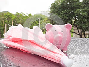 Pink Piggy bank with umbrella On a rainy day Saving money for any storm problem will come concept for finance, insurance,