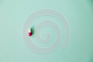  pink pill on a blue background. Minimal concep.