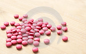 Pink pills on brown background