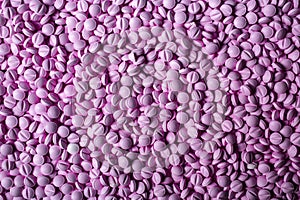 Pink pills lie table background. Drugs, painkillers, colds and other medicines.