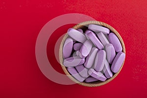 Pink pills in a wooden bowl. Medical medicine. Space for text. Medicine creative concepts photo