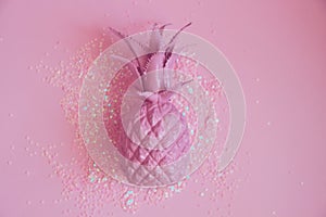 Pink pineapple lying in glitters. Concept minimal photo. Top view