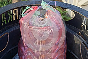 A pink plastic bag full of garbage