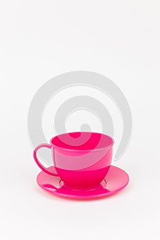 pink plastic cup with saucer on white background