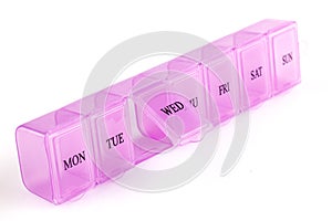 Pink plastic organizer, for pills isolated on white background. Close up on compartments pill case with clip lids medicine. Daily