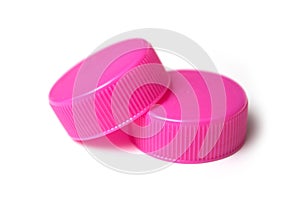 Pink plastic plugs for recycling on white background