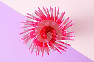 Pink plastic straws on pink and purple background