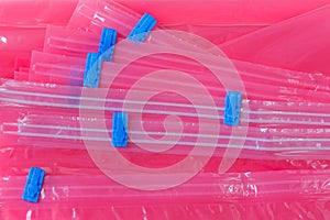 Pink plastic zip lock bag with blue sealing to pack store cloths