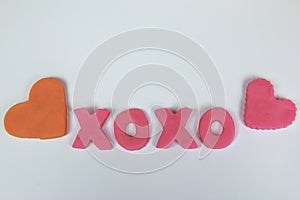 Pink plasticine and clay letters spelling xoxo hugs and kisses w