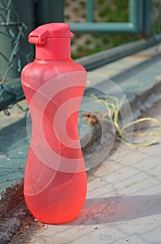 Pink plastik bottle on a sports ground