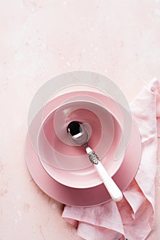 Pink plate, cutlery and napkin on stone table top view. Table setting