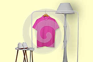 Pink polo shirt hanging on rack isolated on plain background