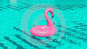 Pink pool. Pink inflatable flamingo in pool water for summer beach background. Pool float party.