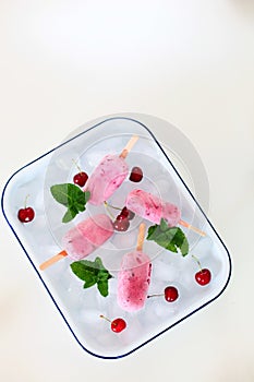 Pink Popsicles with Fruits and Mint on Ice Cubes