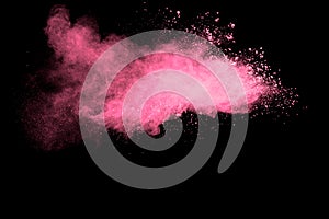 Pink powder explosion on black background.Pink dust splash cloud on dark background