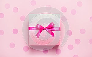 Pink present box on pink konfetti background photo