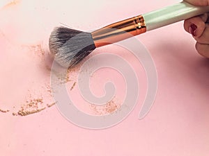 Pink professional makeup brush for powder and eye shadows, isolated on pink background