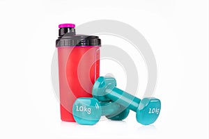 Pink protein blender bottle with a pair of blue fitness dumbbells. Fitness studio concept.