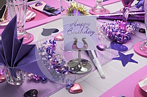 Pink and purple birthday party table setting.