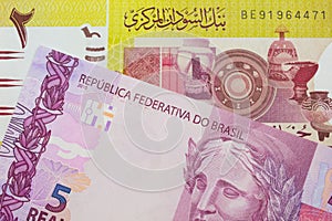 A pink and purple five real bank note from Brazil paired with a green two pound bank note from Sudan.