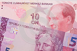 A pink and purple five real bank note from Brazil paired with a purple, five lira bank note from Turkey.