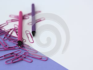 Pink and purple pens and paperclips