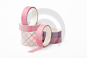 Pink and purple rolls of washi tape on a white