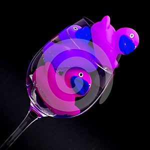 Pink and purple rubber ducks in wineglasses