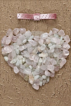 Pink quart and aquamarine crystals heart shape closeup on elegant white