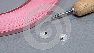 Pink Quilling paper strips and quilling needle with googly eyes for crafts projects