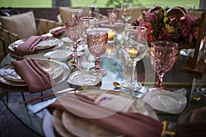 Pink quinceaÃÂ±era sweet sixteen table flower decoration with glass globets wedding event party at night, coctel table with candles photo