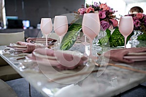 Pink luxury glassware table flower decoration with glass globets wedding event party at night, coctel table with candles photo