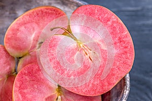 Pink and red fleshed apples on a dark background. Apples with pink flesh