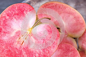 Pink and red fleshed apples on a dark background. Apples with pink flesh