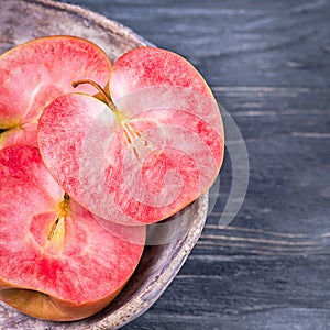 Pink and red fleshed apples on a dark background. Apples with pink flesh