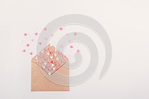 Pink, red and white sweets sugar candy hearts fly out of craft paper envelope on the white background . Valentine day concept. Gif