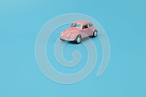 Pink retro car model isolated on a blue background