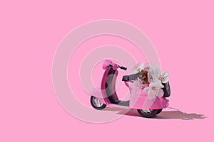 Pink retro toy bike delivering bouquet of flowers on pink background. February 14 card, Valentine`s day. Flower delivery. 8 March