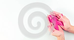Pink ribbon background. Health care symbol pink ribbon in woman hands on white background. Breast cancer support concept