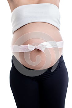 Pink ribbon bow over the pregnant woman`s belly