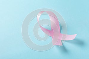 Pink ribbon breast cancer awareness on light blue background