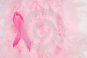 Pink ribbon on feather boa background