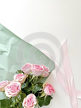 Pink ribbon, flowers and wrapping paper on a light background. Place for text. Gift for Valentine's Day, Mother's Day